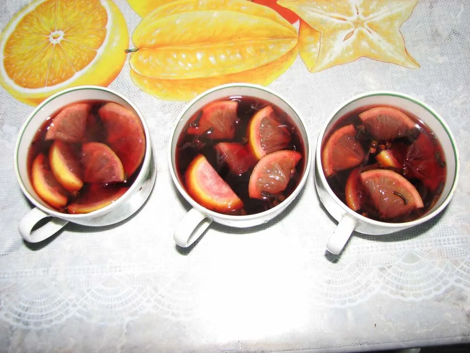 Three cups of mulled wine with citrus fruit