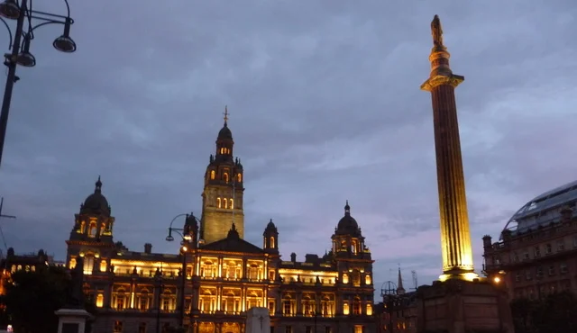 Glasgow City Chambers illuminated at dusk across George Square