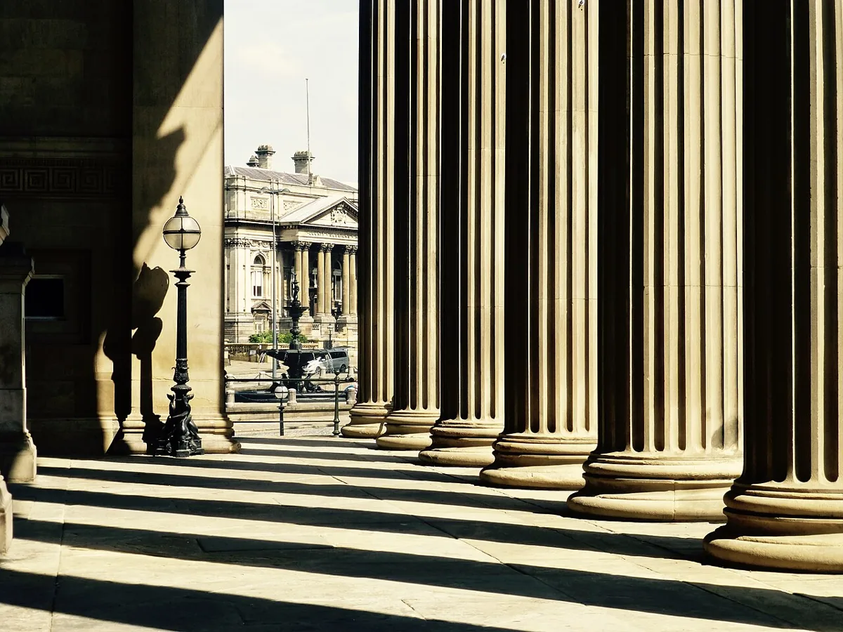 Sunlight and shadows between the stone columns of St George’s Hall, Liverpool